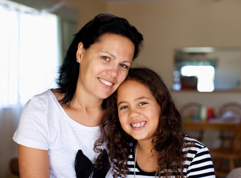 Smiling mother and daughter in their home